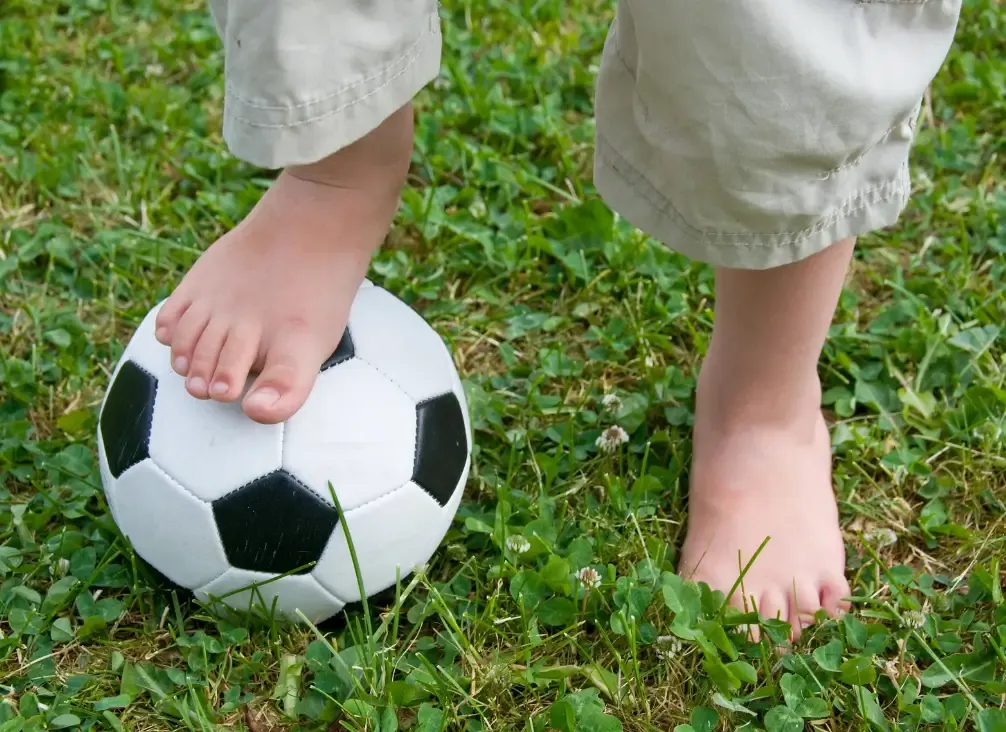 A child holding their heel after sport, the typical presentation of Sever's disease