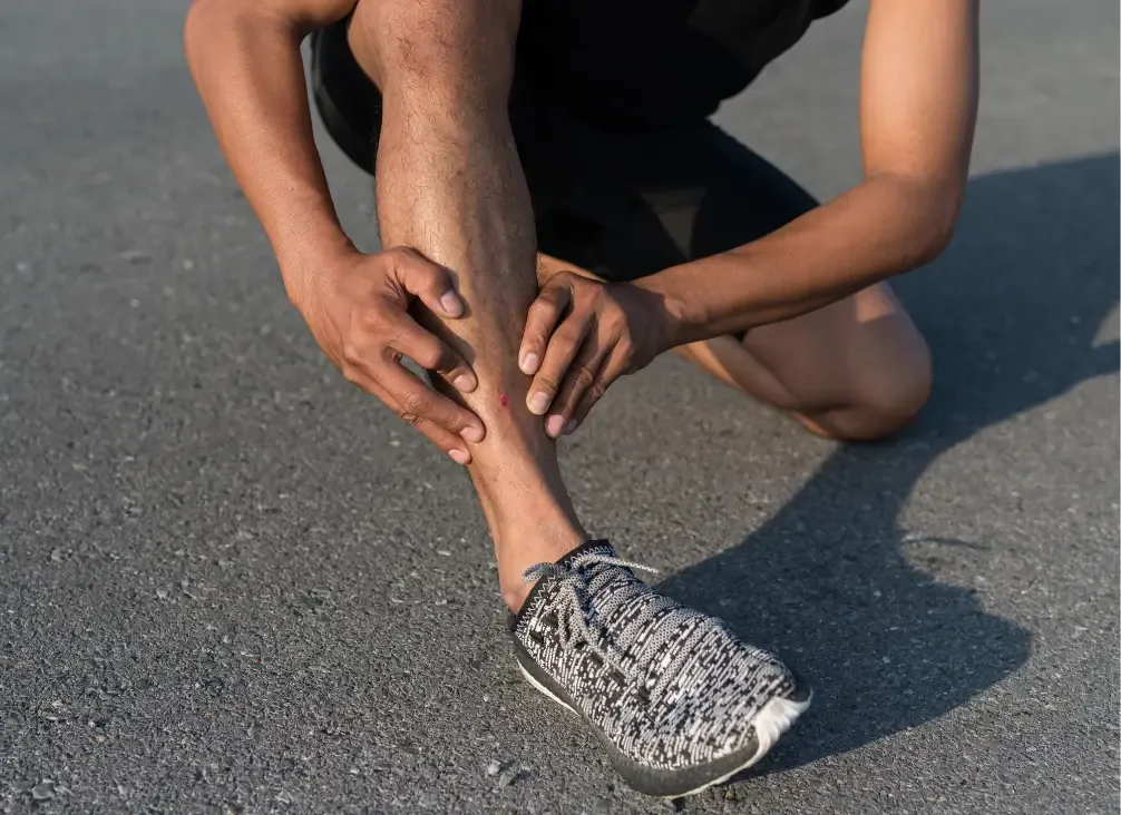 A runner holding the inner edge of their lower leg where shin pain is felt