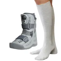 A long grey seamless sock worn up to the knee, beside a grey air moon boot of the kind it goes under