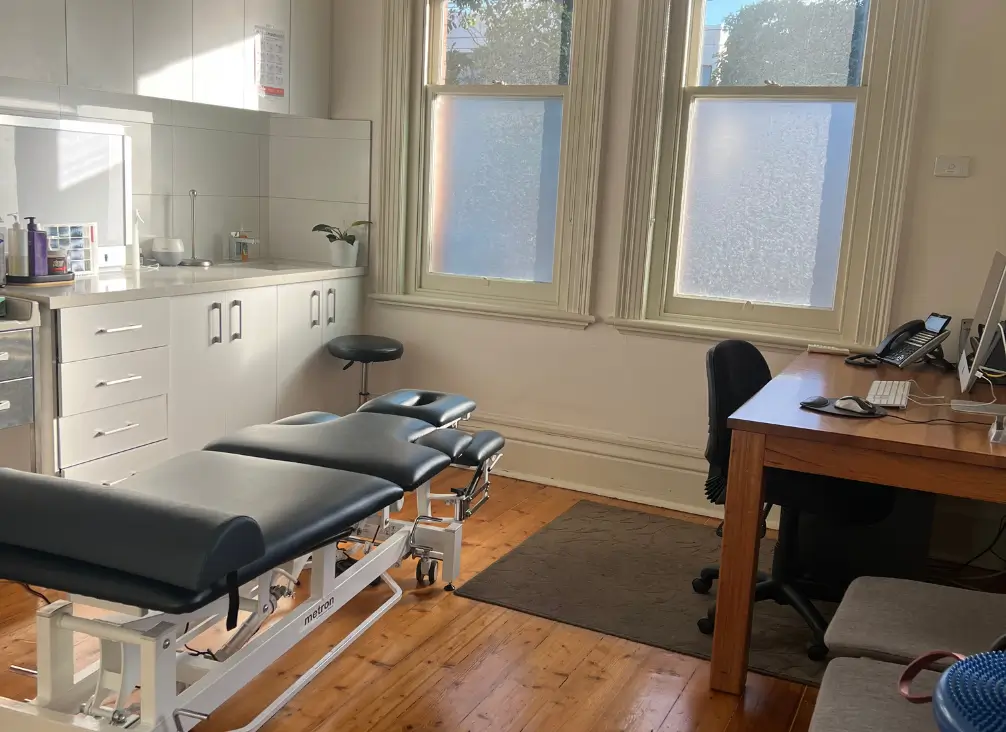 Modern podiatry treatment room in Brunswick with exam table and consultation desk