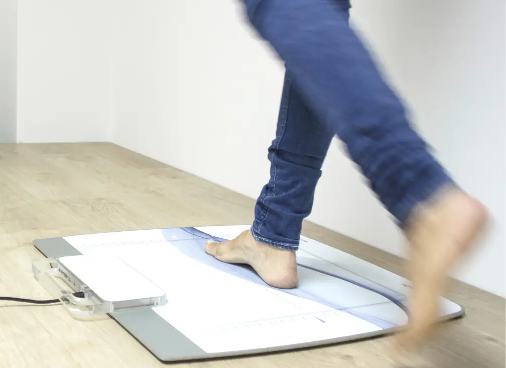 Gait analysis scan for custom foot orthotics at podiatry clinic.