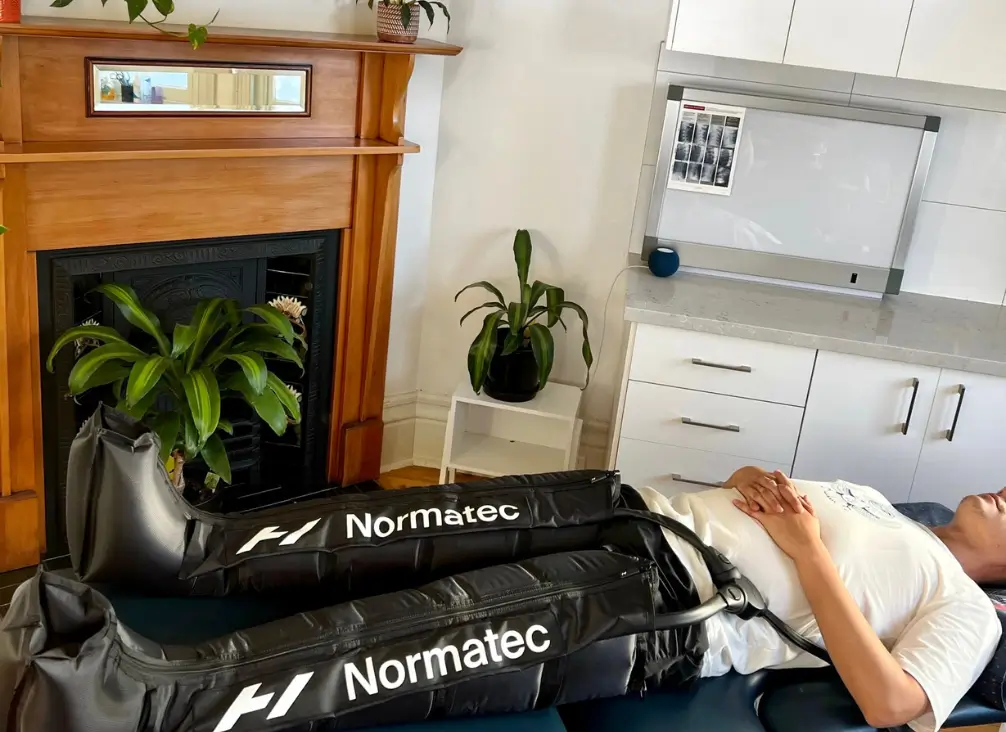 Patient using Normatec compression boots for leg recovery in Brunswick podiatry clinic