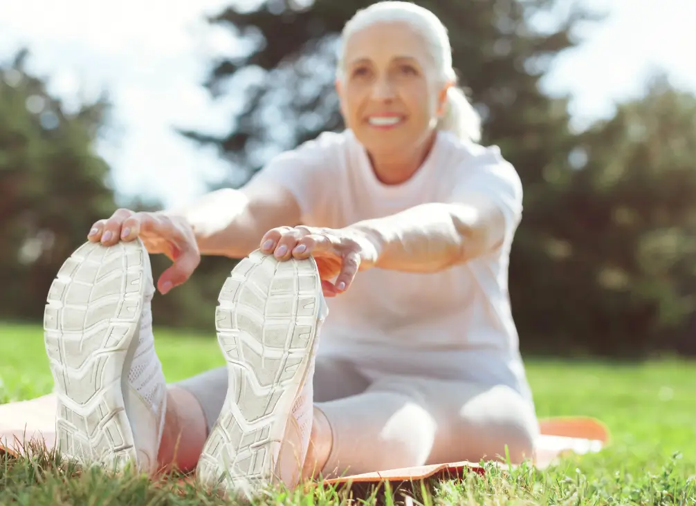 Elderly woman stretching outdoors – active foot care supported by podiatry Brunswick.