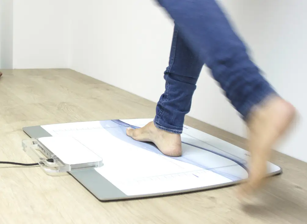 Gait analysis scan for custom foot orthotics at podiatry clinic.