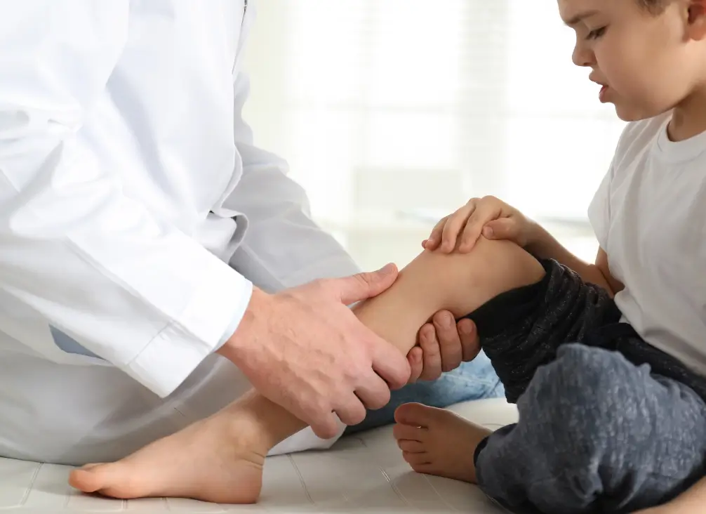 Child receiving knee examination for Osgood-Schlatter disease