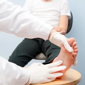 Podiatrist examining plantar wart on child’s foot during treatment