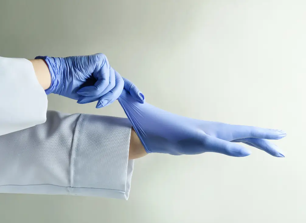 Healthcare professional putting on blue gloves for wart treatment